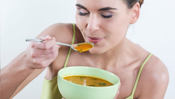 Девушка ест суп